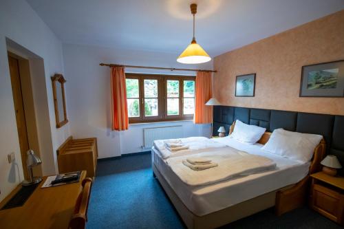 安纳贝格-伦格茨达赫斯坦西运动酒店的一间卧室配有一张床、一张书桌和一个窗户。