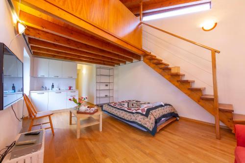 PugernaCasa Gialla - Happy Rentals的一间卧室设有一张床和一个楼梯