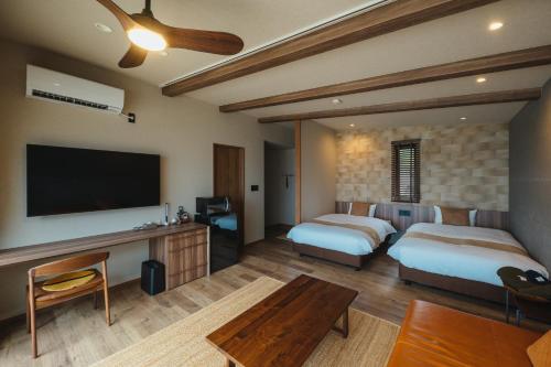 上天草L'isola THE BIRD的酒店客房设有两张床和一台平面电视。