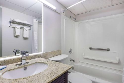 米拉米契Travelodge by Wyndham Miramichi New Brunswick的浴室配有盥洗盆、卫生间和浴缸。