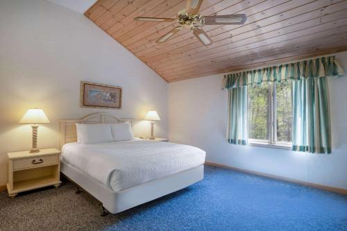 马什皮Southcape Resort Mashpee a Ramada by Wyndham的一间卧室配有一张床和吊扇