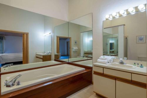 马什皮Southcape Resort Mashpee a Ramada by Wyndham的一间带两个盥洗盆和大镜子的浴室