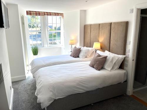 奈恩Altonhill House - room only的一间卧室配有两张带枕头的床和窗户。