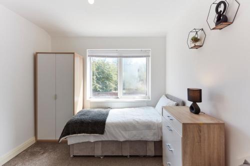 利兹Spacious home close to city centre location的一间卧室设有一张床和一个窗口