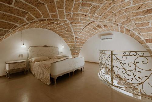 费尔莱恩Borgo Felline Ospitalità Autentica的一间卧室设有一张床和砖墙