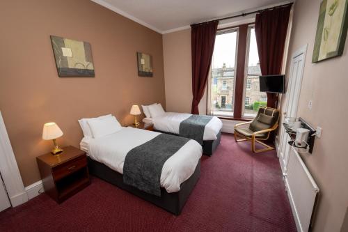 爱丁堡Hampton Hotel by Greene King Inns的酒店客房设有两张床和窗户。