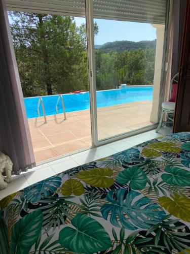 蒙托鲁VILLA MARILIS的一间卧室配有一张床,享有游泳池的景色