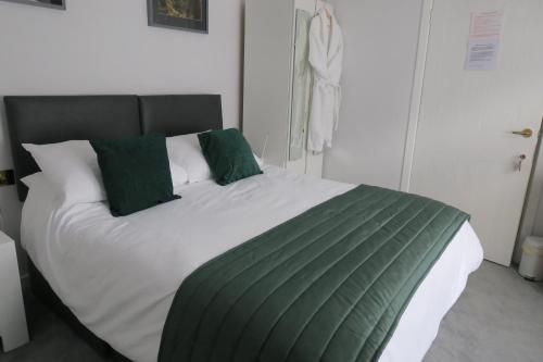 柯库布里Barr Hill Woods B&B的一间卧室配有一张带绿色枕头的大床
