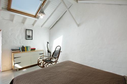 克鲁兹·德·特赫达Casa Cueva Tejeda 2 dorm的一间卧室配有一张床、一把椅子和一个梳妆台