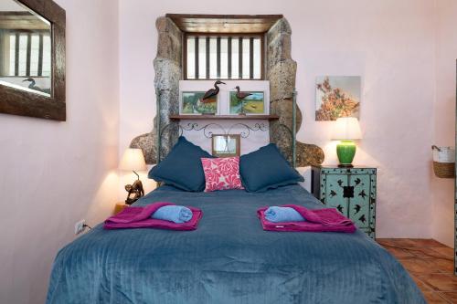 马赫El Cello的一间卧室配有蓝色的床和两个枕头