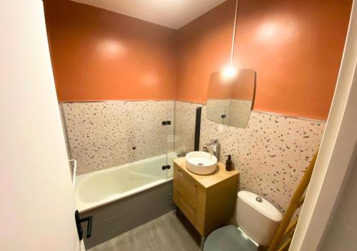 普瓦捷Côté Cour - Poitiers - La Conciergerie.的浴室配有盥洗盆、卫生间和浴缸。