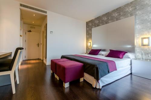 梅里那德奥拉菲YIT塞维利亚迈雷纳大街酒店的一间卧室配有一张带紫色枕头的大床