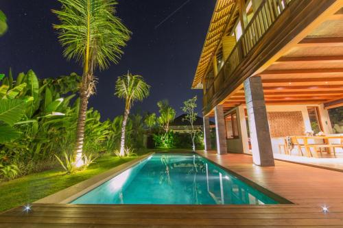 乌鲁瓦图梅拉利滨宁旅馆的棕榈树屋前的游泳池