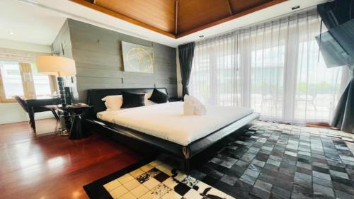 北芭堤雅Yizen Beachfront Seaview Villa的一间带一张大床的卧室,位于带窗户的房间内