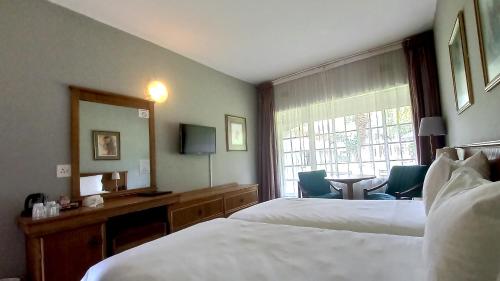 BoshoekSundown Country Estate的酒店客房设有两张床、一张书桌和一个窗户。