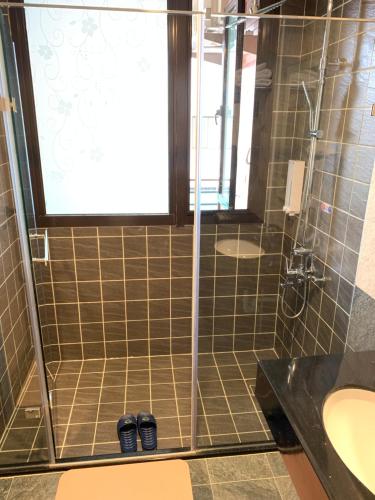 金宁乡金门幸福渡假行馆的浴室配有水槽和带两鞋的淋浴