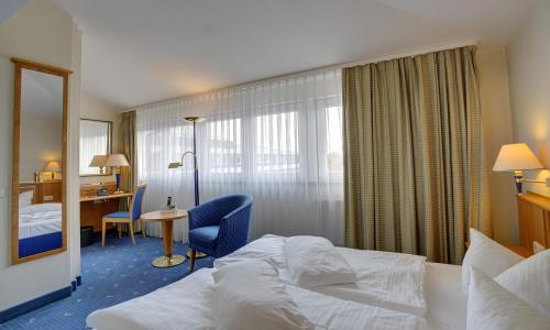 马格德堡ACHAT Hotel Magdeburg的配有一张床和一张书桌的酒店客房