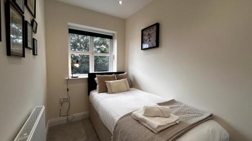 奥尔德肖特Newbuild, 3 Bedroom house with free parking的一间小卧室,配有床和窗户