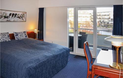 赫尔辛格M-613纳德斯特拉维公寓的配有一张床、一张书桌和一扇窗户的酒店客房