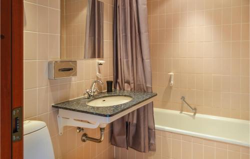 赫尔辛格M-613纳德斯特拉维公寓的浴室配有盥洗盆和浴缸。