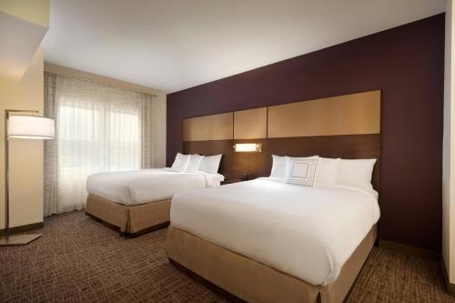 温斯顿·塞勒姆Residence Inn by Marriott Winston-Salem Hanes Mall的酒店客房设有两张床和窗户。