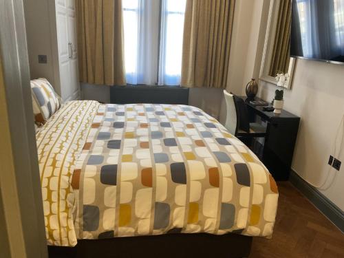 伦敦Queens View的一间卧室配有一张带 ⁇ 子毯子的床