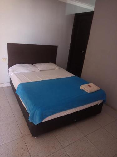 MaicaoComfort inn的卧室内的一张床铺,上面有蓝色的毯子