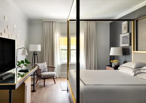 萨凡纳金普顿布赖斯酒店的一间卧室配有一张床、一张书桌和一台电视
