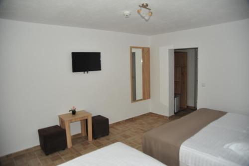 南埃福列Hotel Ancora的一间卧室设有两张床,墙上配有电视。