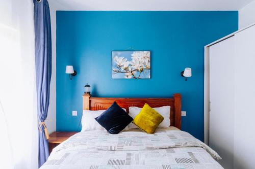 FumbaFumbatown Cozy 1 bed Apartment的蓝色卧室配有带黄色枕头的床