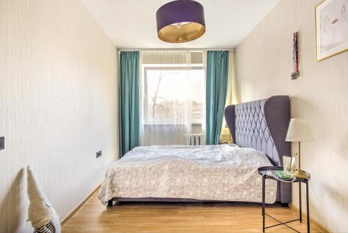 维尔纽斯Cozy flat near city center and airport. FREE PARKING的一间卧室设有一张床和一个窗口