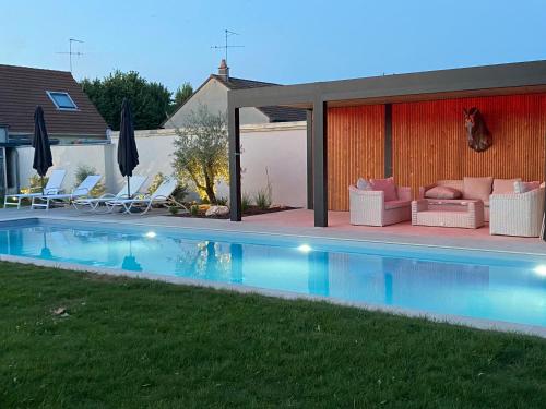 LarçayLe cheval bleu的后院设有游泳池、椅子和房屋