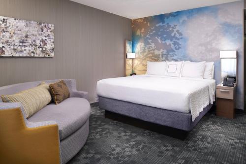 独立市克利夫兰独立万怡酒店的配有一张床和一把椅子的酒店客房