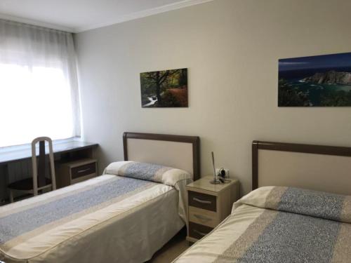 希洪CasaBlanca的一间卧室设有两张床和窗户。