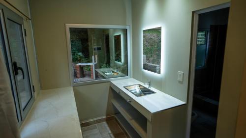 圣萨尔瓦多德朱Eco lodge de la selva的一间带水槽和镜子的浴室