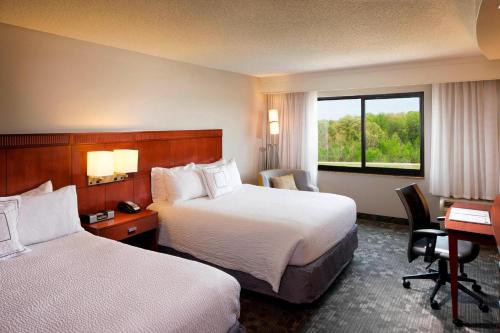 杰克逊杰克逊万怡酒店的酒店客房设有两张床、一张书桌和一个窗户。