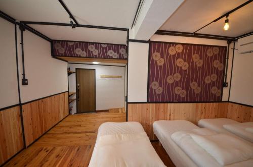 那霸GRANDPA'S HOUSE Barchanchi - Vacation STAY 53569v的一间设有两张床和鲜花的墙壁的房间