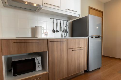 普吉镇Квартира с рабочим столом X413 by IBG Property的厨房配有冰箱和微波炉。