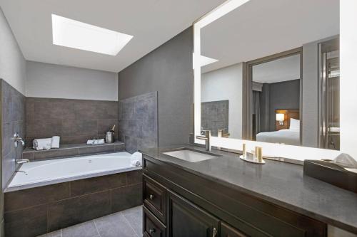 埃尔姆赫斯特芝加哥艾姆赫斯特/奥克布鲁克地区万怡酒店的带浴缸、水槽和镜子的浴室
