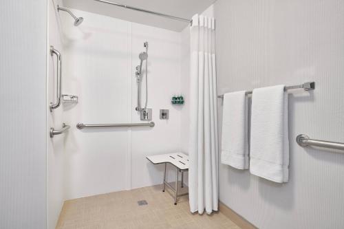林夕昆高地巴尔的摩华盛顿国际机场万怡酒店的带淋浴和桌子的白色浴室