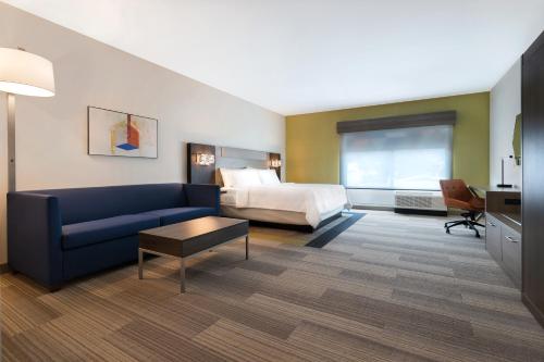 格伦代尔Holiday Inn Express & Suites - Glendale Downtown的酒店客房设有一张沙发和一张床