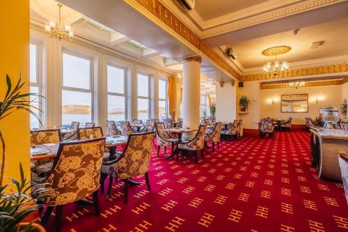奥本穆图亚历山德拉酒店的一间铺有红地毯并配有桌椅的用餐室