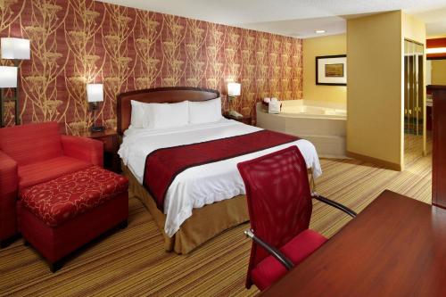 阿尔图纳阿尔图纳万怡酒店的酒店客房带一张床、椅子和浴缸