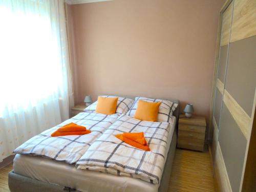 佩奇Árkád Apartman-Pécs的一间卧室配有带橙色枕头的床