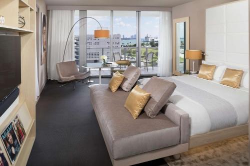 迈阿密The Gabriel Miami Downtown, Curio Collection by Hilton的酒店客房设有一张大床和一张沙发。