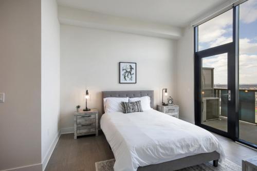 亚特兰大Luxury 2bdrm Penthouse in Midtown的白色的卧室设有床和大窗户