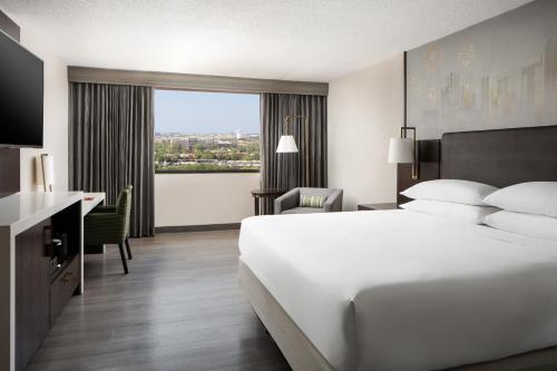 达拉斯达拉斯艾迪森科然姆商业街廊万豪酒店的配有一张床、一张书桌和一扇窗户的酒店客房