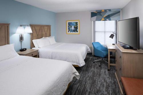圆石城Hampton Inn Austin Round Rock的酒店客房设有两张床和一台平面电视。