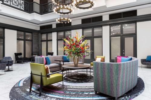 纳什维尔Homewood Suites by Hilton Nashville Downtown的大堂设有椅子和一张带花瓶的桌子