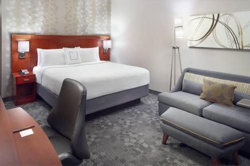 夏洛特夏洛特南方公园万怡酒店的酒店客房,配有床和沙发